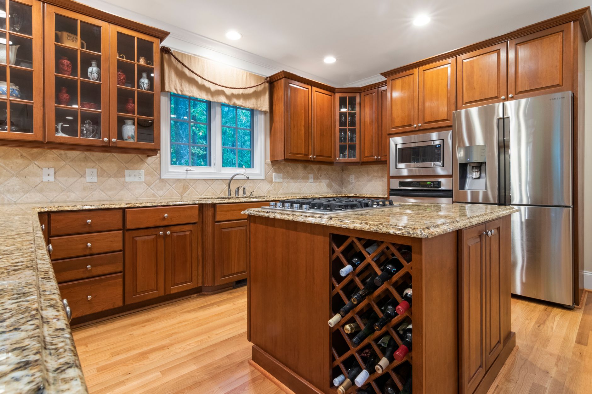 Stylish kitchen featuring wooden cabinetry, modern appliances, and granite countertops for a luxurious feel